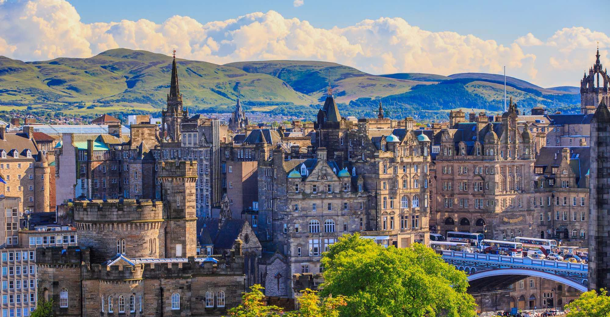Image shows Edinburgh city with rolling hills in the background