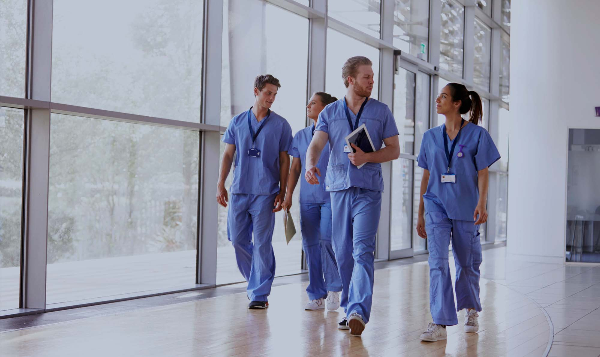 Image shows a group of medical students walking down a hospital corridor 