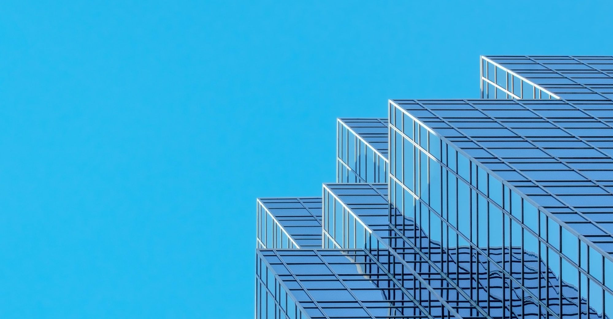 Image shows high-rise architecture under a bright blue sky